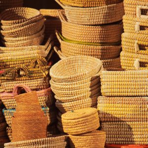 Vibrant handmade woven baskets stacked in a market, showcasing craftsmanship.