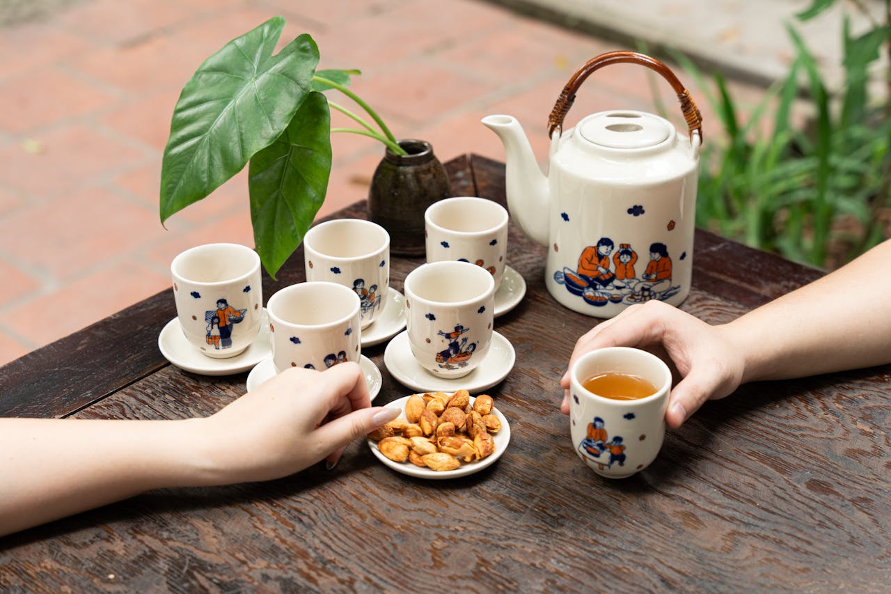 Relaxed afternoon tea setup with ceramic cups and teapot, showcasing artistic designs, perfect for a cozy atmosphere.