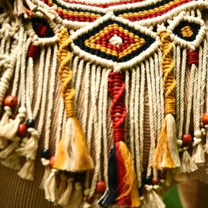 Intricately designed macrame wall hanging with colorful patterns and beads.