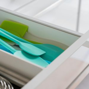 A tidy kitchen drawer featuring organized silicone spatulas and a whisk.