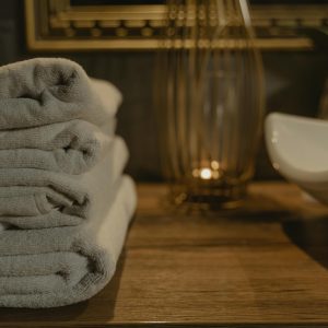 Elegant white towels neatly stacked in a cozy bathroom ambiance with soft lighting.